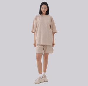 White London Clothing beige oversized textured shorts with elasticated waistband and subtle logo accent on left leg.