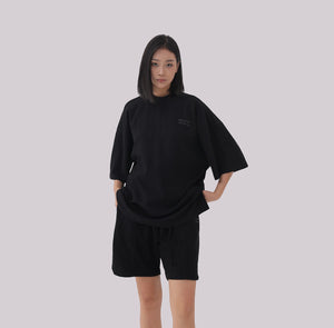 White London Clothing black oversized textured jersey shorts with elasticated waistband and subtle logo detail.