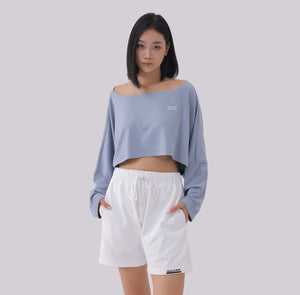 White London Clothing light blue oversized fit long sleeve cropped sweatshirt with a wide neckline and white logo detail.