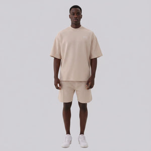 White London Clothing beige oversized textured shorts with elasticated waistband and subtle logo detail on left leg.