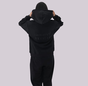 White London Clothing black 100% cotton hoodie with a double-lined hood and printed logo on the back. Model is wearing a size medium.