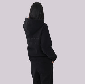 White London Clothing black 100% cotton hoodie with large logo print on back and small logo on chest. Model wearing medium.