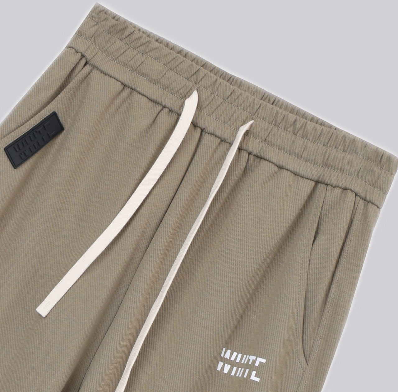White London Clothing beige casual fit trousers with drawstring and logo detail.