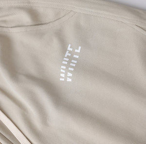 White London Clothing beige relaxed fit trousers with drawstring and white logo detail.