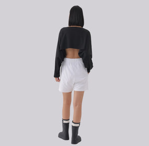 White London Clothing black oversized cropped sweatshirt with long sleeves, worn with white shorts and black boots.