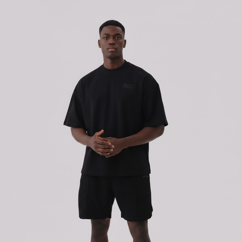 White London Clothing black oversized textured shorts made from heavyweight cotton jersey with an elasticated waistband and subtle logo detail.