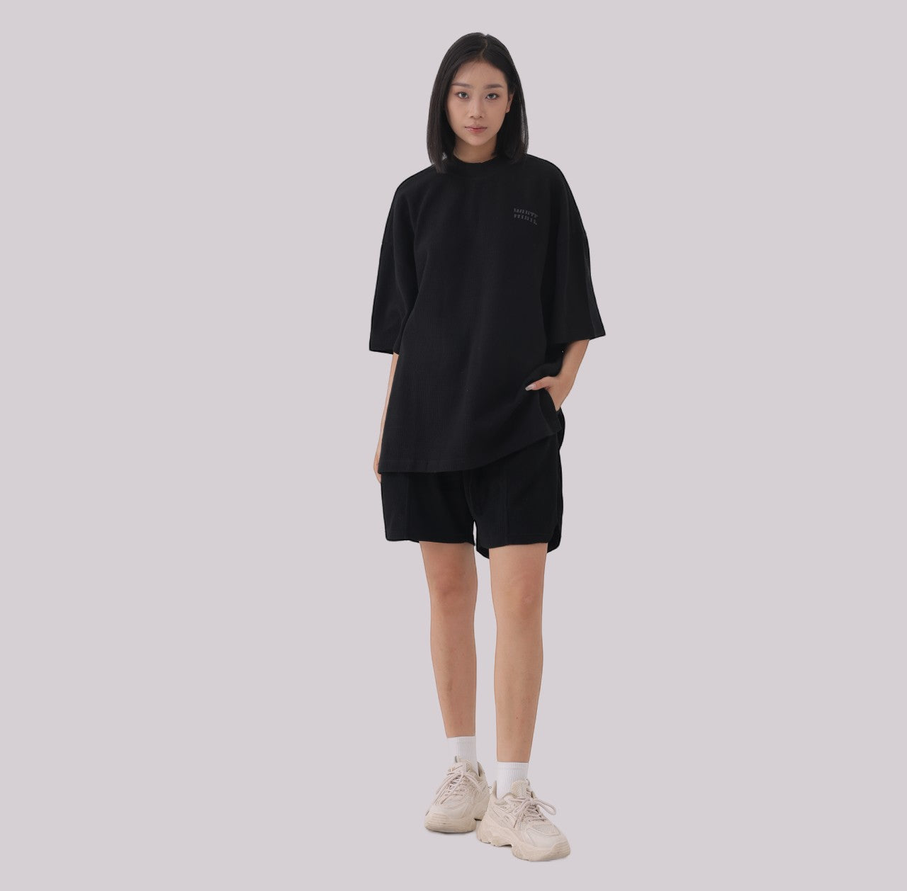 White London Clothing black oversized textured jersey shorts with elasticated waistband and subtle logo accent.