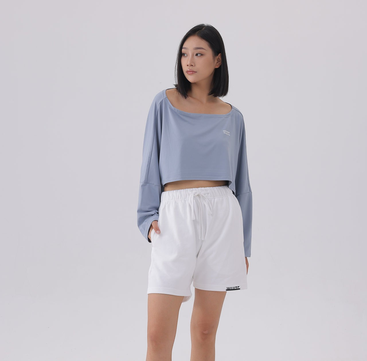 White London Clothing blue oversized fit long sleeve cropped sweatshirt with a square neckline and white logo detail.