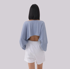 White London Clothing light blue oversized cropped long sleeve sweatshirt with open back detail, paired with white shorts.