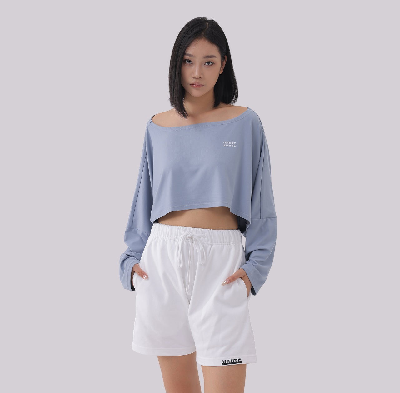 White London Clothing light blue oversized fit long sleeve cropped sweatshirt with a wide neckline and white logo detail.