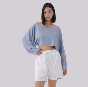 White London Clothing light blue oversized cropped long sleeve sweatshirt with white logo detail, paired with white shorts.