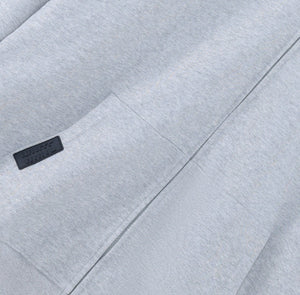 White London Clothing grey jersey zip-up hoodie with dropped shoulders and a black logo patch on the chest.
