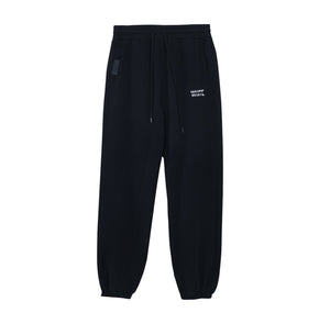 White London Clothing navy blue cotton jersey joggers with signature silhouette, cropped length, and white logo print on left thigh.