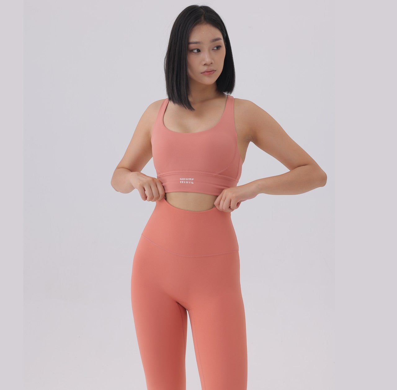 White London Clothing coral pink sculpt sports bra with spaghetti straps and removable padding. Moisture-wicking.