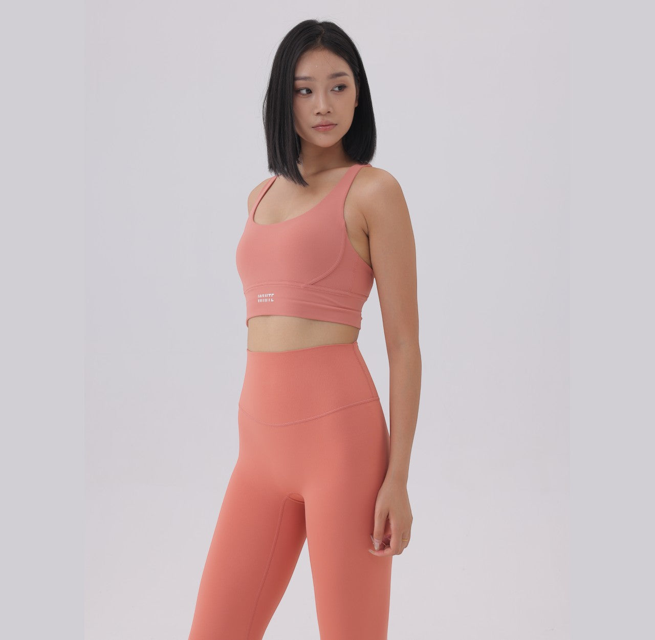White London Clothing coral pink sculpt sports bra with spaghetti straps and removable padding.