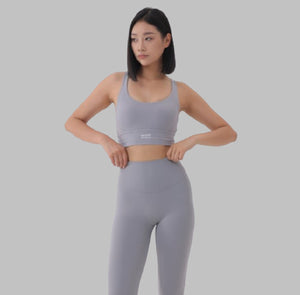 White London Clothing light grey sculpt sports bra with spaghetti straps and removable padding. Moisture-wicking fabric.