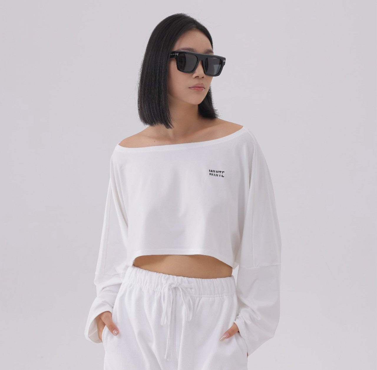 White London Clothing white oversized fit long sleeve cropped sweatshirt with black logo detail on chest.