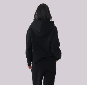 White London Clothing black 100% cotton hoodie with large logo print on back and embossed logo tag on pocket. Model wearing medium.