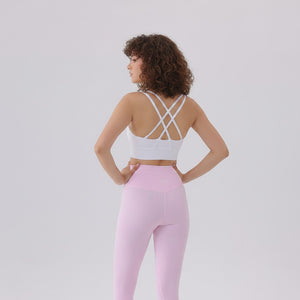 White London Clothing women's light pink high-waisted sculpt leggings with a V-shaped waistband and a white criss-cross back sports bra.