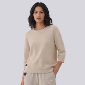 White London Clothing taupe knitted sweater with 3/4 sleeves and crew neck. Features a small black logo patch on the left hip.