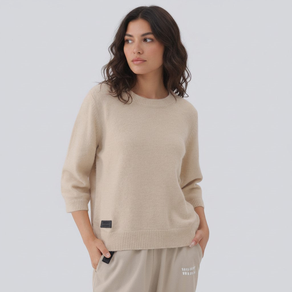 White London Clothing taupe knitted sweater with 3/4 sleeves and a crew neck, featuring a small black logo patch on the left chest.